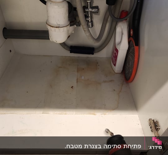 צנרת וסיפון מתחת לכיור לצד כלי לפתיחת סתימות